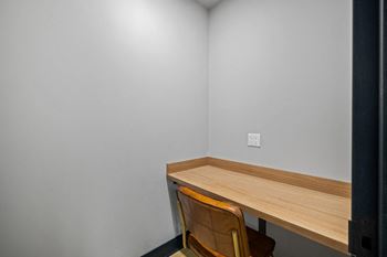 a desk and chair in a room with white walls